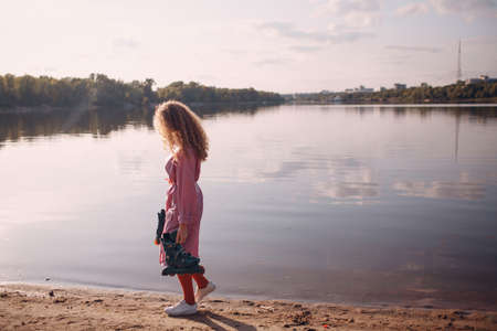 Young curly teenager woman with roller skates outdoor