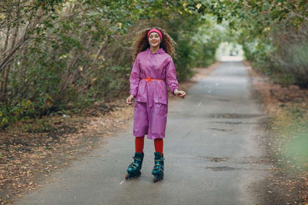 Young curly teenager woman with roller skates outdoorの写真素材