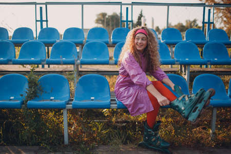 Young curly teenager woman with roller skates outdoorの写真素材