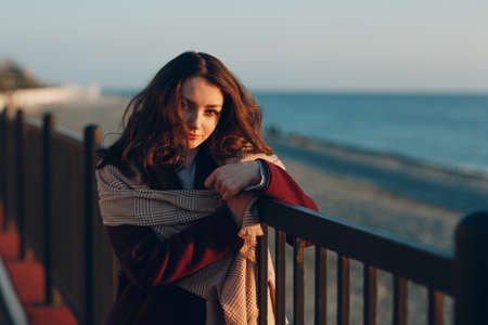 Young woman in coat at coast outdoorsの写真素材