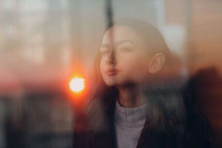 Beautiful young teenager girl portrait behind window glass.の写真素材