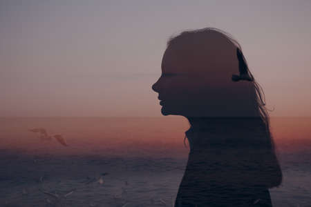 Young beautiful woman profile silhouette portrait at sunsetの写真素材