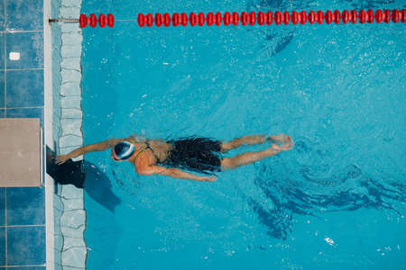 Young woman sporty professional swimmer swim in swimming poolの写真素材