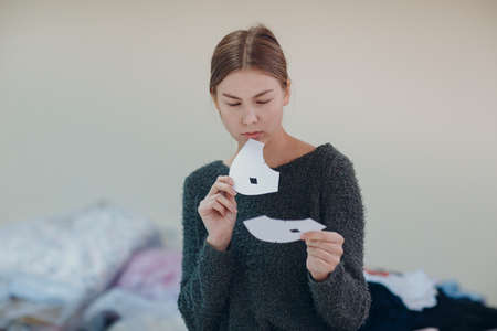 Young beautiful seamstress cutter clothing designer with pattern and template in garment factoryの写真素材