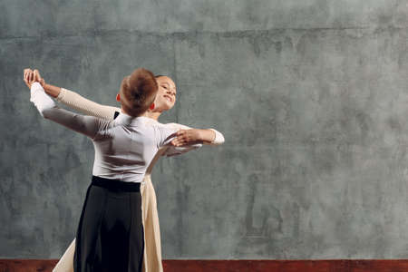 Young boy and girl dancing in ballroom dance Viennese Waltz.の写真素材
