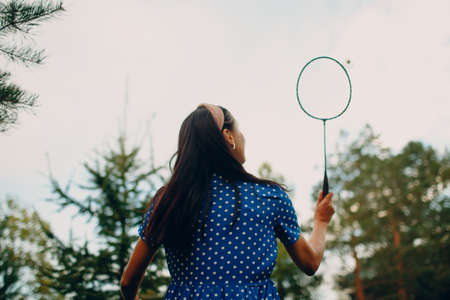 Young adult woman playing badminton in the park.の写真素材