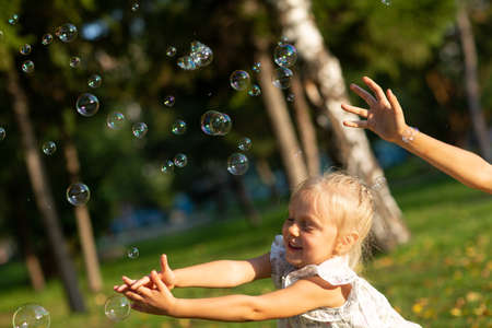 Cute little children boy and girl blowing bubbles in autumn park on sunny day.の写真素材