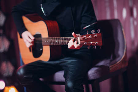 Closeup of a man hands strumming acoustic guitar.の写真素材