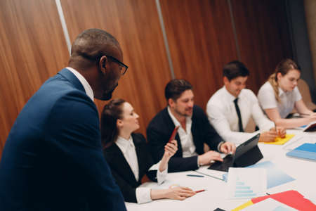 Businessman african boss and businesswoman team at office meeting. Business people group conference discussion sit at table with boss man and womanの写真素材