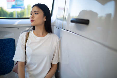 Asian Woman take a ride sit in public transport bus or tram vehicleの写真素材