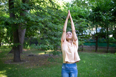 Indian woman doing yoga in outdoor summer park.の写真素材