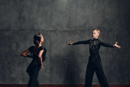 Couple in black costumes dancing in ballroom rumba danceの写真素材