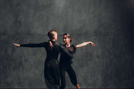 Pair dancers in black costumes dancing in ballroom rumba danceの写真素材