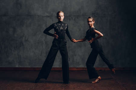 Couple in black costumes dancing in ballroom rumba danceの写真素材