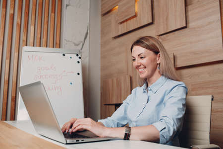 Business woman young adult coach at office with laptop