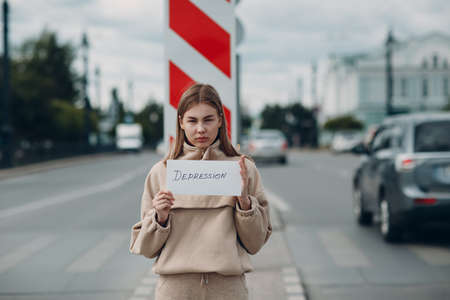 Woman holding white sheet paper labeled word Depression in handの写真素材