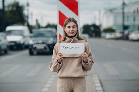 Hidden depression concept. Woman smiling holding white sheet paper labeled word Depression in handの写真素材