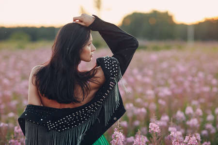 Young brunette woman on blooming Sally flower field. Lilac flowers and girlの写真素材