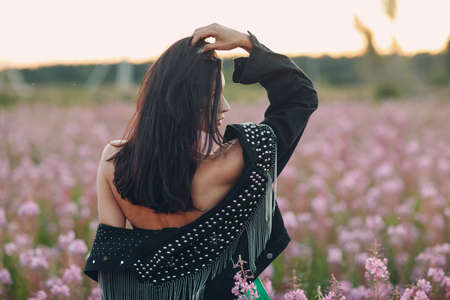 Young brunette woman on blooming Sally flower field. Lilac flowers and girlの写真素材