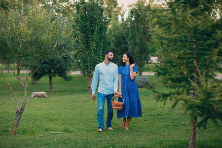 Happy Couple with Fruits in Picnic Basket Walking in the Parkの写真素材