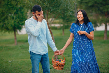 Happy Couple with Fruits in Picnic Basket Walking in the Parkの写真素材