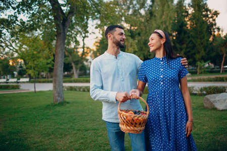 Happy Couple with Fruits in Picnic Basket Staying in the Parkの写真素材