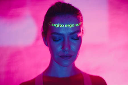 Young adult woman with words Cogito Ergo Sum translated from Latin language as I Think Therefore I am on her face.の写真素材