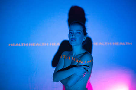 Young adult woman with word Health on her bodyの写真素材