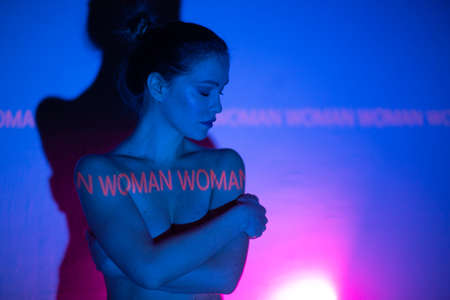 Young adult woman with word Woman on her body.の写真素材