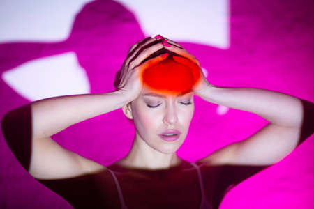 Young woman with headache and red color forehead.の写真素材