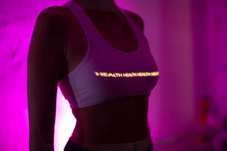 Young adult woman with word Health on her body in darkの写真素材