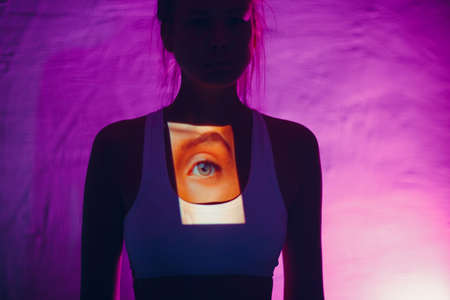 Blind woman with eye on her breast in dark.の写真素材