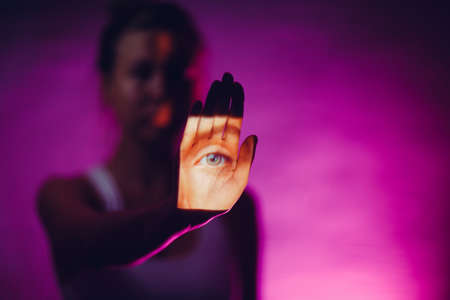 Blind woman with eye on her hand palm in dark.の写真素材