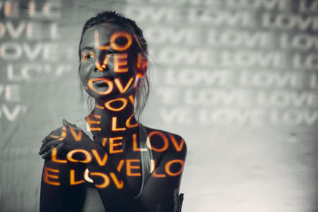 Young adult woman with word Love on her body.の写真素材