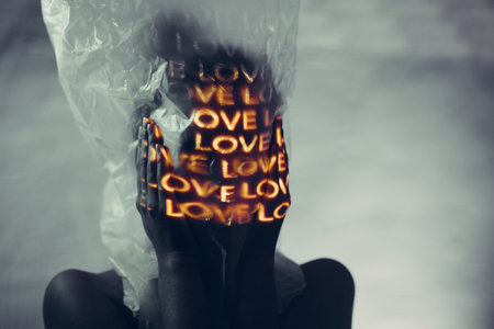 Young adult woman with word Love on her head in plastic bag.の写真素材