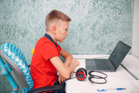 Young student boy with laptop learning and preparing back to school.の写真素材