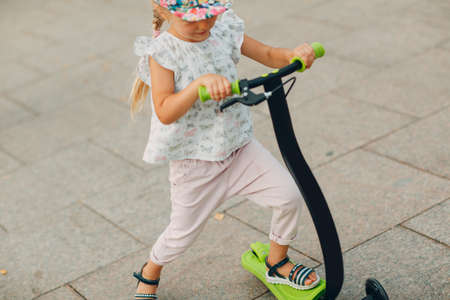 Little girl using a scooter on the city streetの写真素材