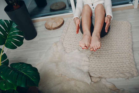 Adult woman doing yoga at home living room with online tutorials on laptopの写真素材