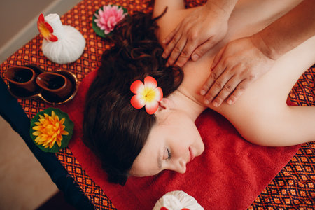Thai man making classical thai massage procedure to young woman at beauty spa salon top viewの写真素材