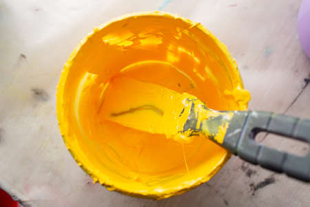 Serigraphy silk screen print process at clothes factory. Plastisol yellow color paints at table.の写真素材