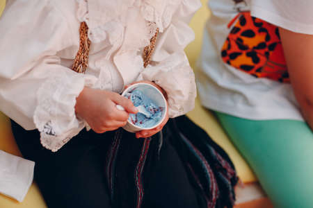 a child in a suit eats lilac ice cream and a cup.の写真素材