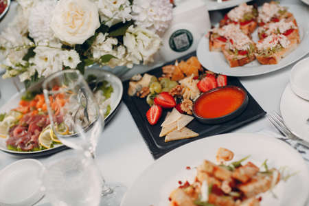 Food catering appetizers snacks on a tray on table with white flowers.の写真素材