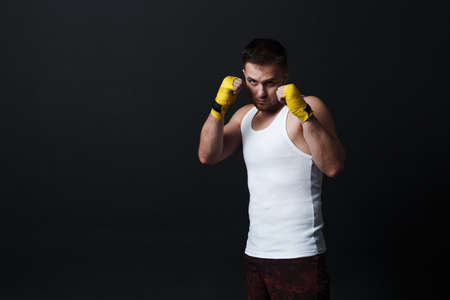 Sportsman muay thai man boxer stance at black background.の写真素材