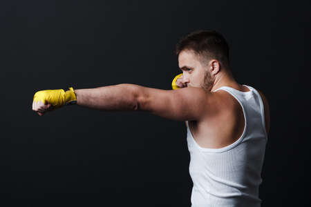 Sportsman muay thai man boxer stance at black background.の写真素材