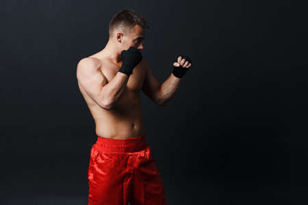 Man bare knuckle fighter stand at black background.の写真素材