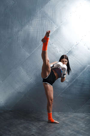 Sportsman muay thai woman boxer posing in training studioの写真素材