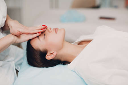 Beautiful young woman getting face treatment massage at beauty spaの写真素材