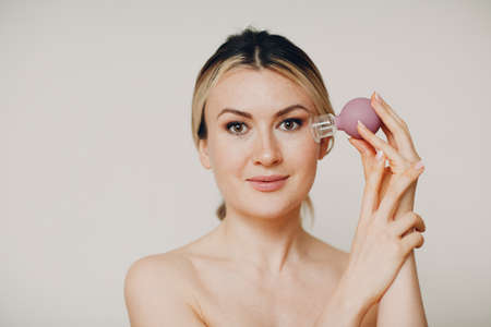 Cupping therapy procedure, woman with little medical cup for faceの写真素材