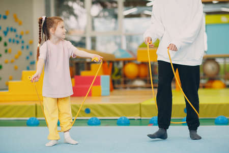 Kids doing exercises with skipping rope in gym at kindergarten or elementary school. Children sport and fitness conceptの写真素材