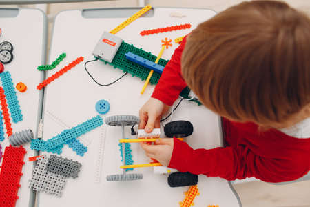 Little boy kid child constructor checking technical toy. Children Robotics constructor assemble...